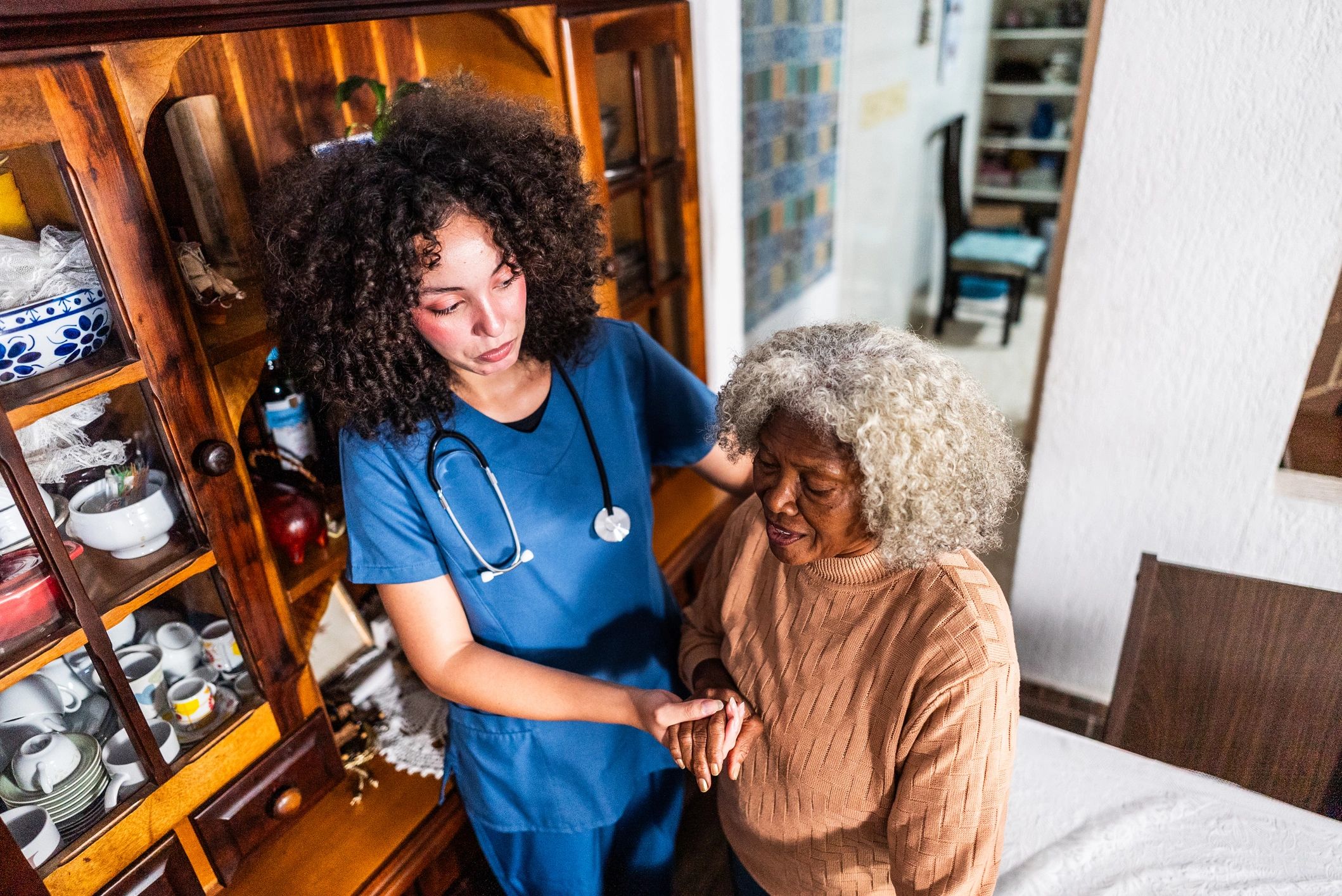 Caregiver assisting a senior woman in a supportive home care environment